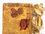 a close up of a gold and red clock on a table