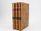 two old books sitting on top of each other on a white surface