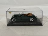 a green toy car in a clear box on a table
