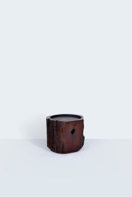 une photo d'un petit bougeoir en bois posé sur une surface blanche