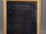 an antique gold framed mirror with a black background and gold trim