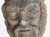a stone head of a man with a crown on his head