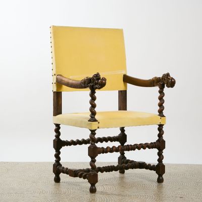 an image of a yellow leather chair with a wooden frame and wooden legs
