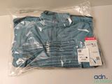 une chemise bleue dans un sac en plastique posé sur une table