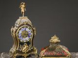 une petite horloge posée à côté d'une autre, plus petite, sur une table