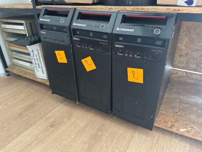 three computers that are sitting on top of a table