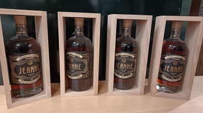 trois bouteilles d'alcool dans des caisses en bois posées sur une table
