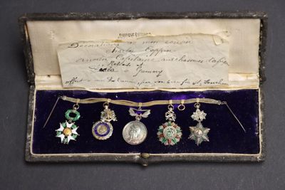 une image d'une boîte contenant une collection de médailles et une lettre