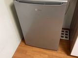 a small refrigerator in the corner of a room