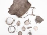 an assortment of silver jewelry including a purse, ring, and other items
