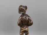 a bronze statue of a man with a hat on his head