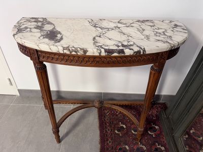 une table au plateau en marbre et au piètement en bois, posée sur un tapis