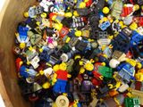 a wooden bowl full of lego minifigurts sitting on top of a table