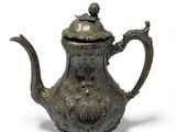 an old silver teapot with a bird on top of it