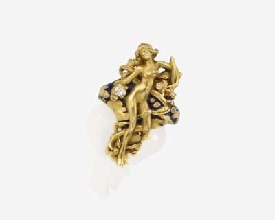 un gros plan d'une bague en or ornée d'une statuette