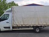 un camion blanc avec une bâche à l'arrière, garé sur un parking