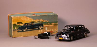 a black toy car and a black toy car in front of a box