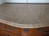 a marble top chest of drawers in a room