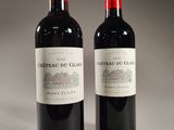 two bottles of red wine sitting next to each other