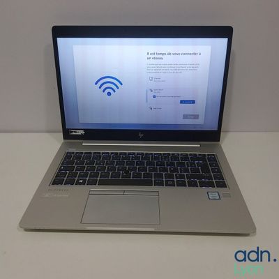 un ordinateur portable posé sur une table, avec le symbole du Wi-Fi affiché à l'écran