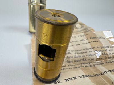 un petit briquet doré posé sur un bout de papier