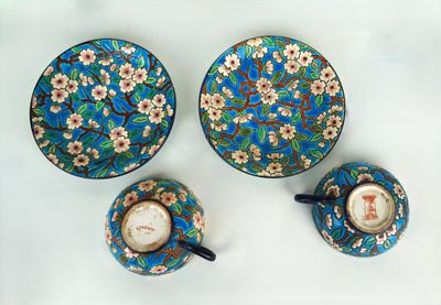 trois tasses et soucoupes posées sur une table, ornées de fleurs