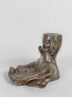 une petite statue représentant une femme tenant une coupe