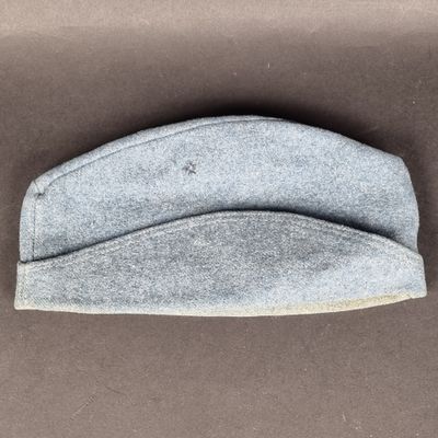 un gros plan d'un chapeau gris posé sur une surface marron
