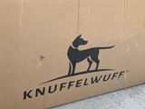 a cardboard box with a dog on it sitting on the ground