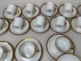 a lot of white and gold coffee cups and saucers on the table