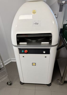 une machine posée par terre à côté d'une étagère