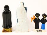 three figurines of people standing next to each other