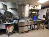a large stainless steel kitchen with a sink and a stove