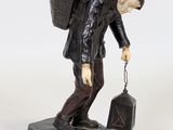 figurine of a man carrying a bag and a suitcase