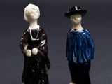 deux figurines d'un homme et d'une femme debout l'un à côté de l'autre