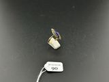 a close up of a ring and a tag on a table