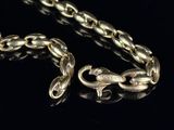 an image of a gold chain on a black surface