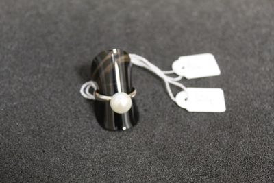 une bague ornée d'une perle, posée sur une table