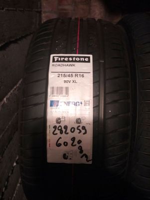 tires on a brick wall with a price tag attached to them