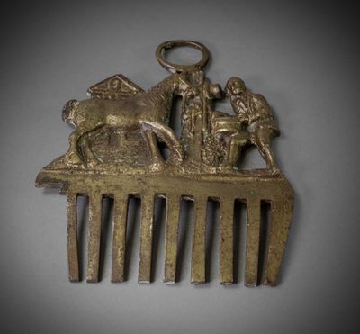 a gold comb with a picture of a man and a woman on it