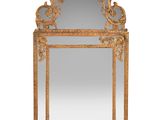 an ornate gold mirror with a bird motif on the frame