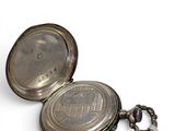 a silver pocket watch with a chain on a white background