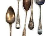six spoons are lined up in a row on a white surface