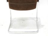 a brown chair that is sitting on a white surface