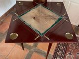 a small table with a glass top on a tile floor