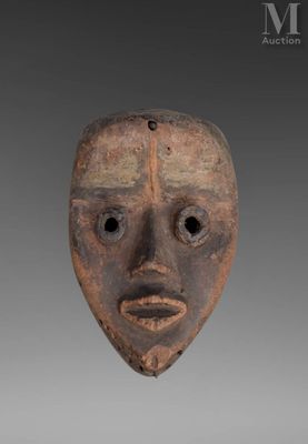 a close up of a wooden mask on a gray background