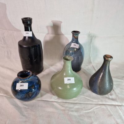 quatre vases différents posés sur une table, sur lesquels sont apposées des étiquettes