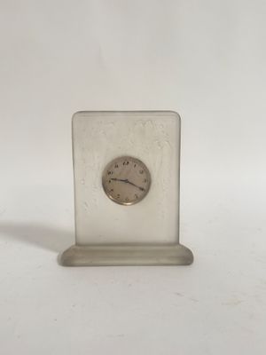 une petite horloge posée sur une table