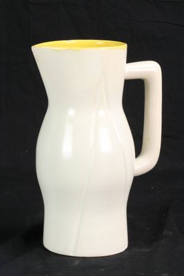un vase blanc avec un couvercle jaune sur fond noir