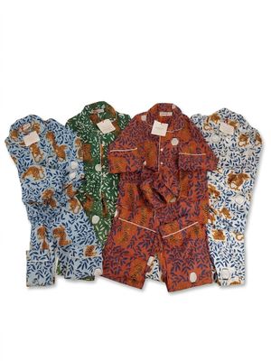 Trois pyjamas pour homme sont alignés sur une surface blanche